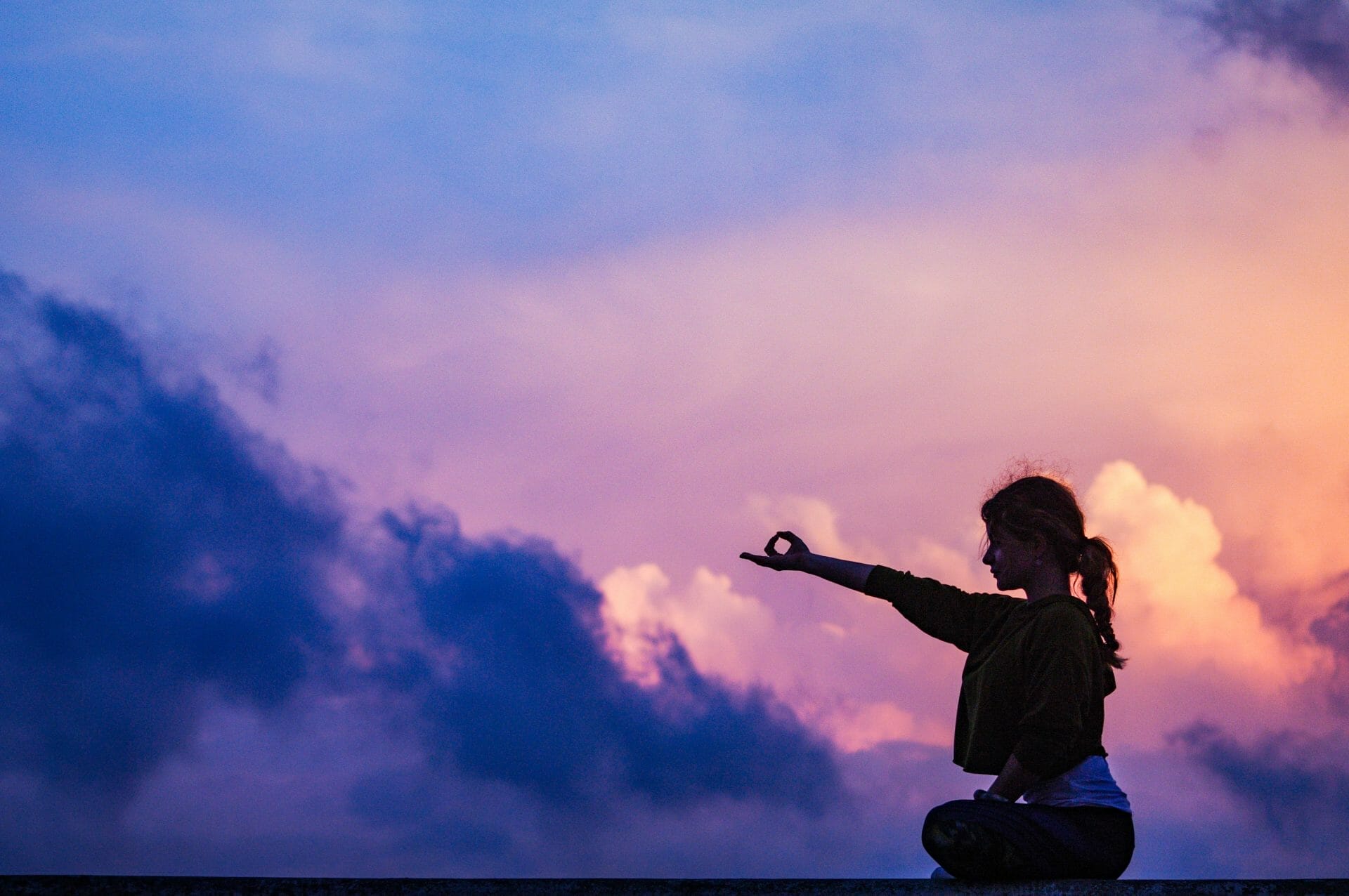 woman-sitting-meditating-and-reaching-her-hands-forwards